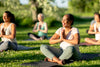 mature women practicing yoga in the grass