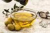 pouring olive oil into small glass bowl