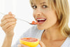woman eating a grapefruit with a spoon