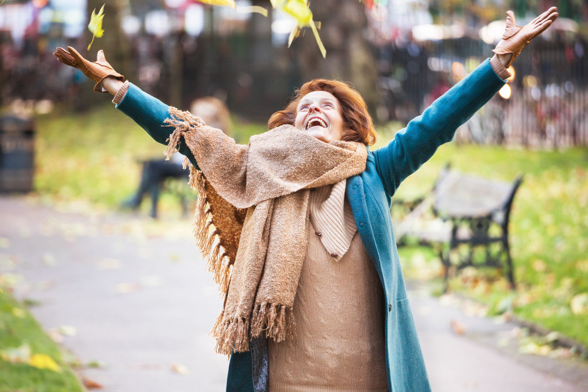 happy senior woman embracing the fall air outside.
