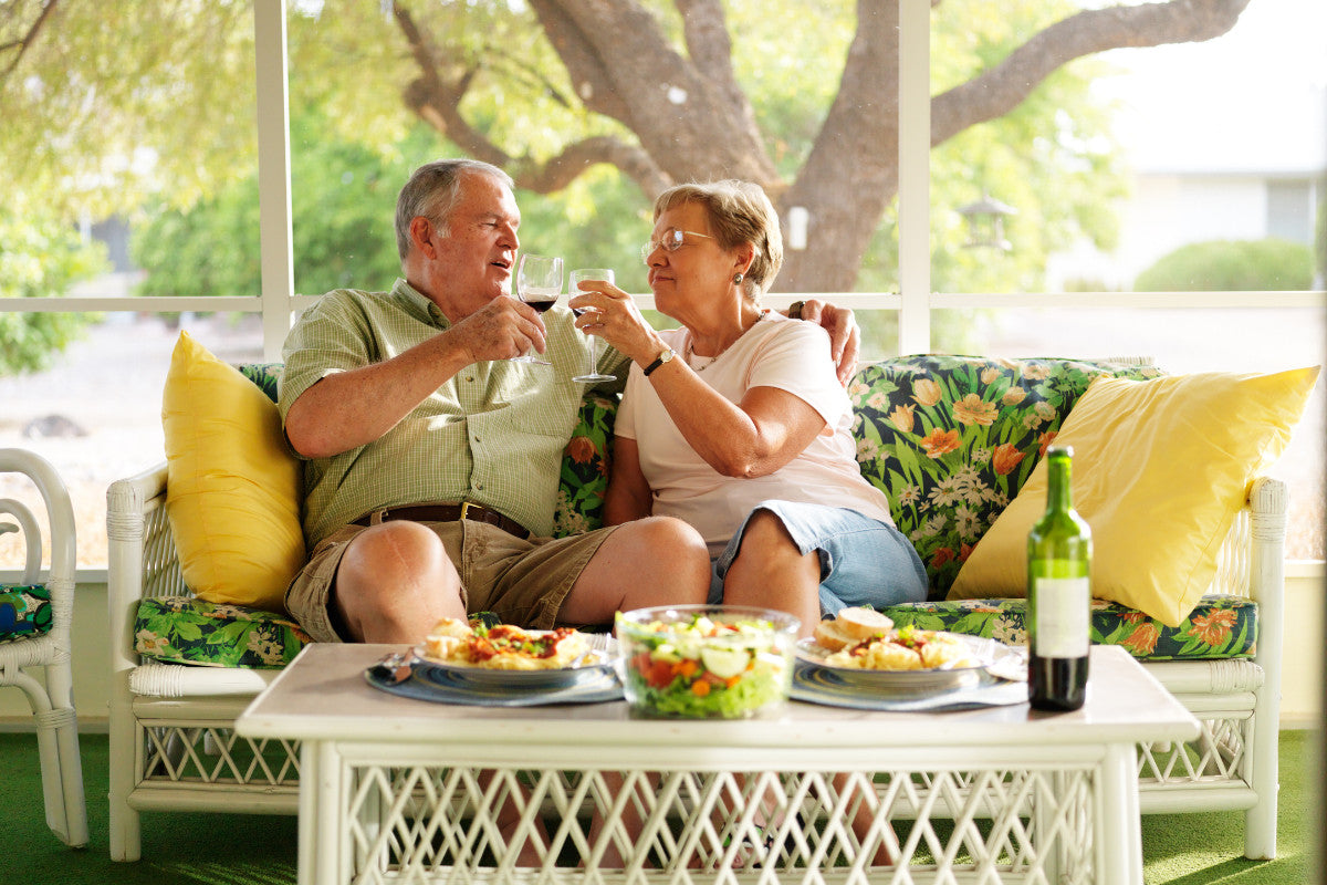Senior couple enjoying lunch together on their patio during summer.