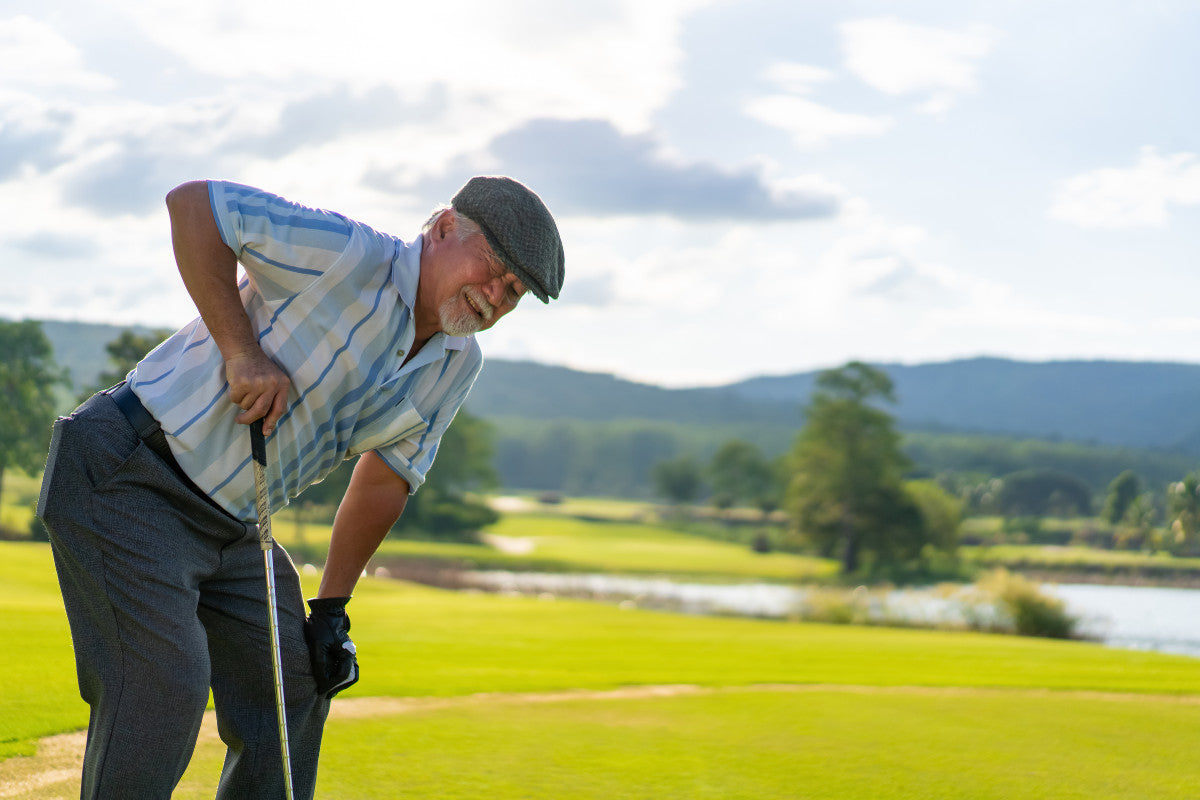 Senior in pain while golfing at a country club in summer.