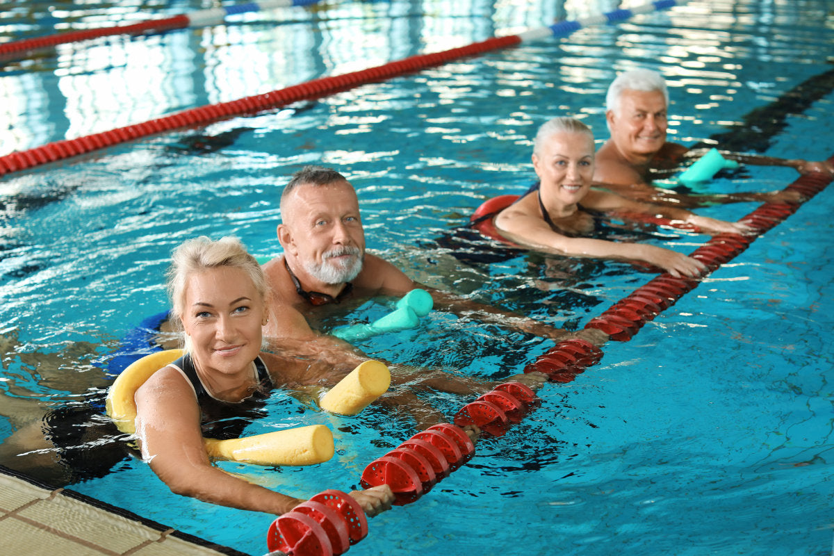 4 seniors swimming in a lap pool