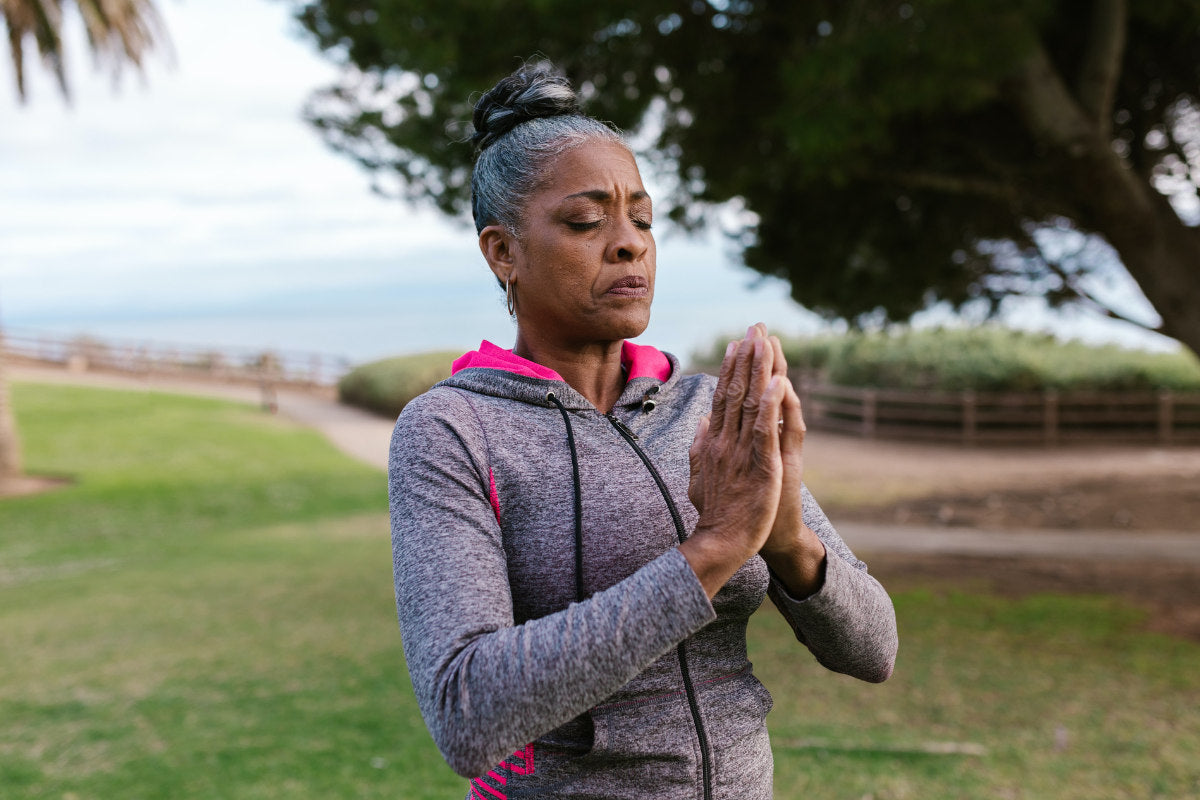 older woman practicing yoga outside