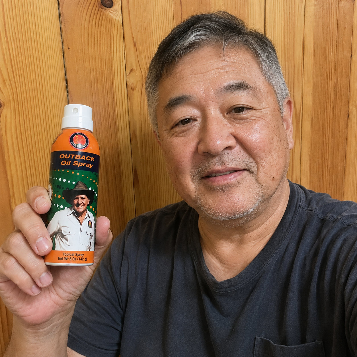 Smiling man holding a can of Outback Original Oil Spray