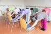group of seniors practicing chair yoga inside a studio
