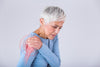 older woman holding her right shoulder in pain