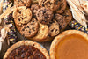 chocolate chip cookies, pecan pie, and pumpkin pie sitting on table