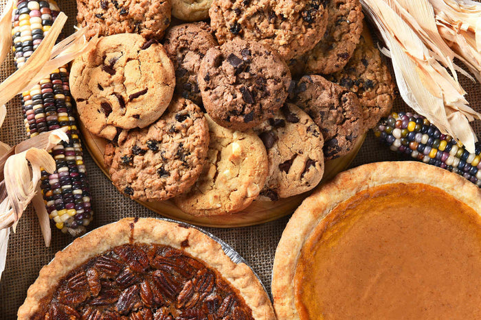 chocolate chip cookies, pecan pie, and pumpkin pie sitting on table
