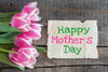 pink and white tulips laid sideways next to a piece of paper that reads 