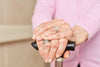 close-up of senior woman's hands crossed over her cane