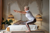 senior woman practicing yoga poses in her bedroom.