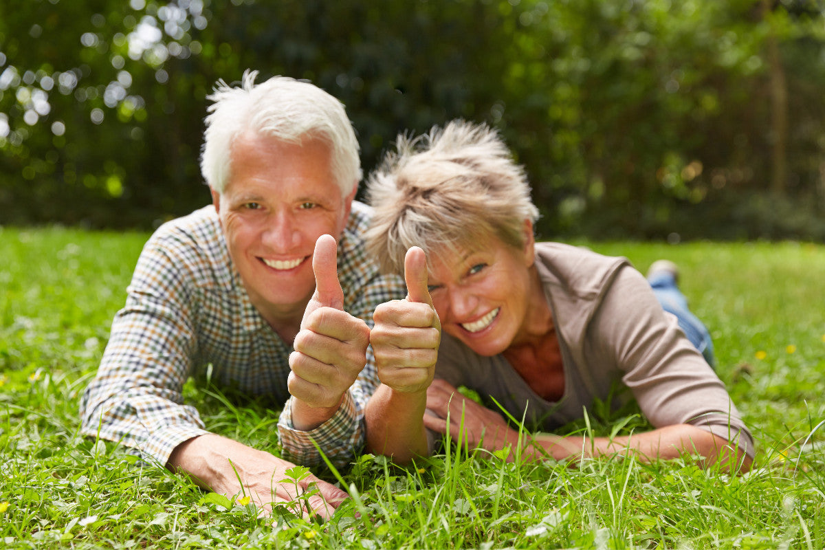 a senior couple smiling and giving a 