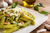 penne pasta with spinach walnut pesto and mozzarella cheese on top.