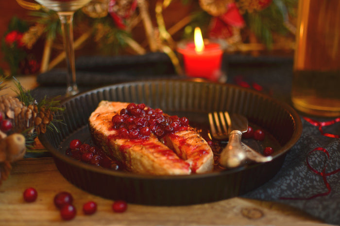 cozy image of salmon covered in cranberry sauce.