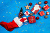 bright blue background with a red stocking spilling with gifts