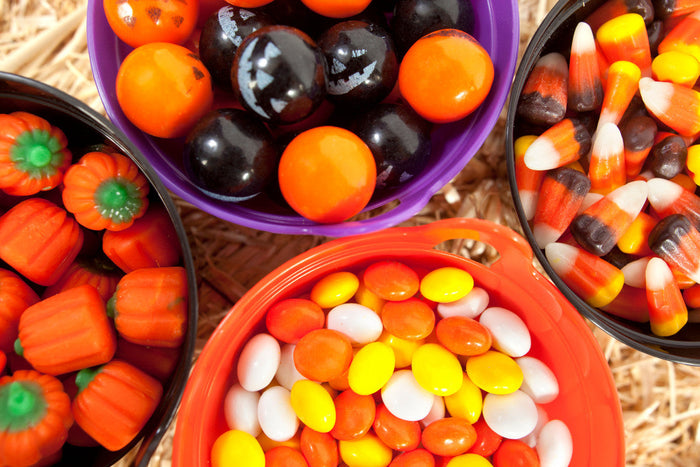 4 different colored buckets filled with Halloween candy