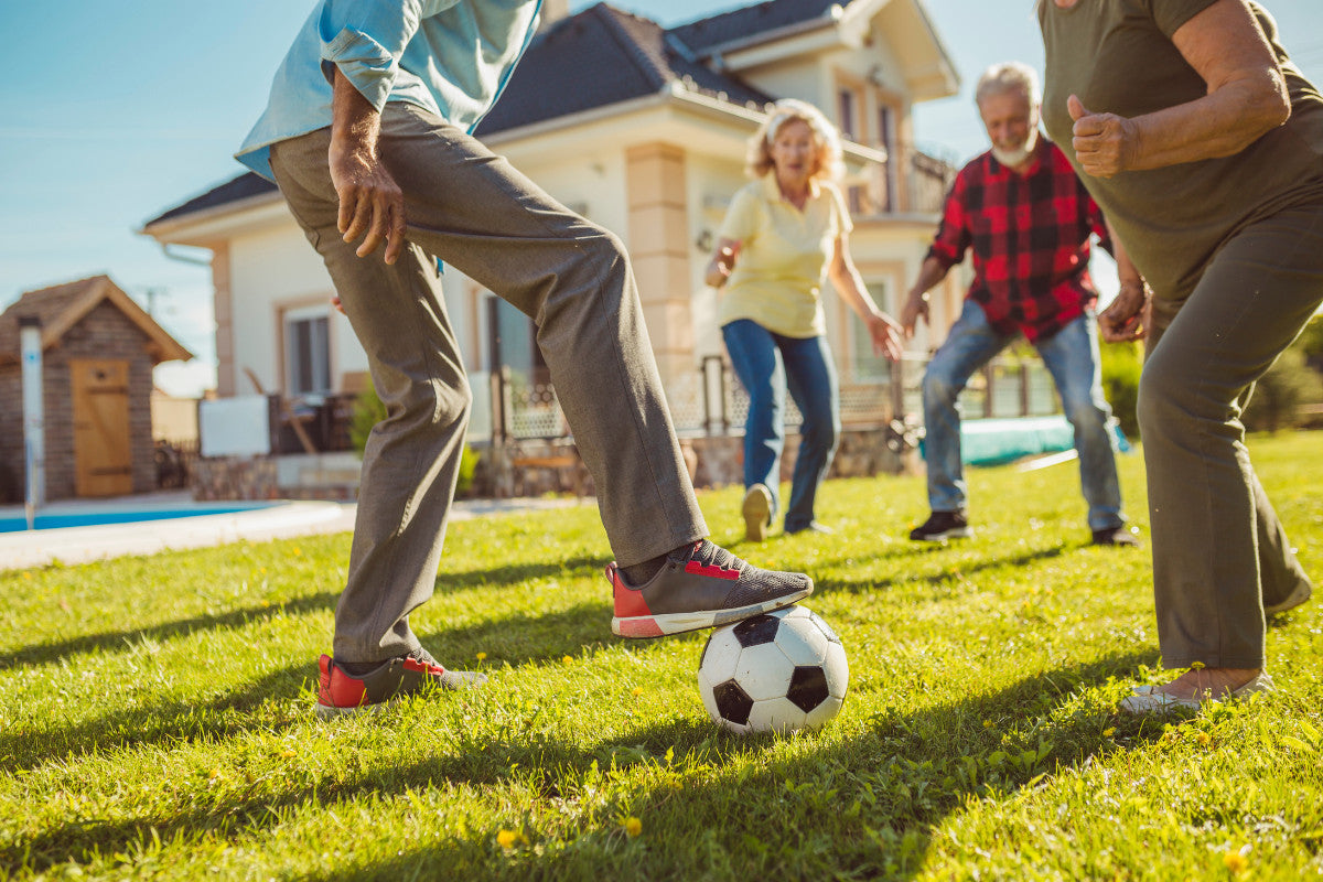 Seniors playing soccer in the back yard.