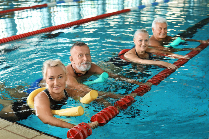 4 seniors swimming in a lap pool