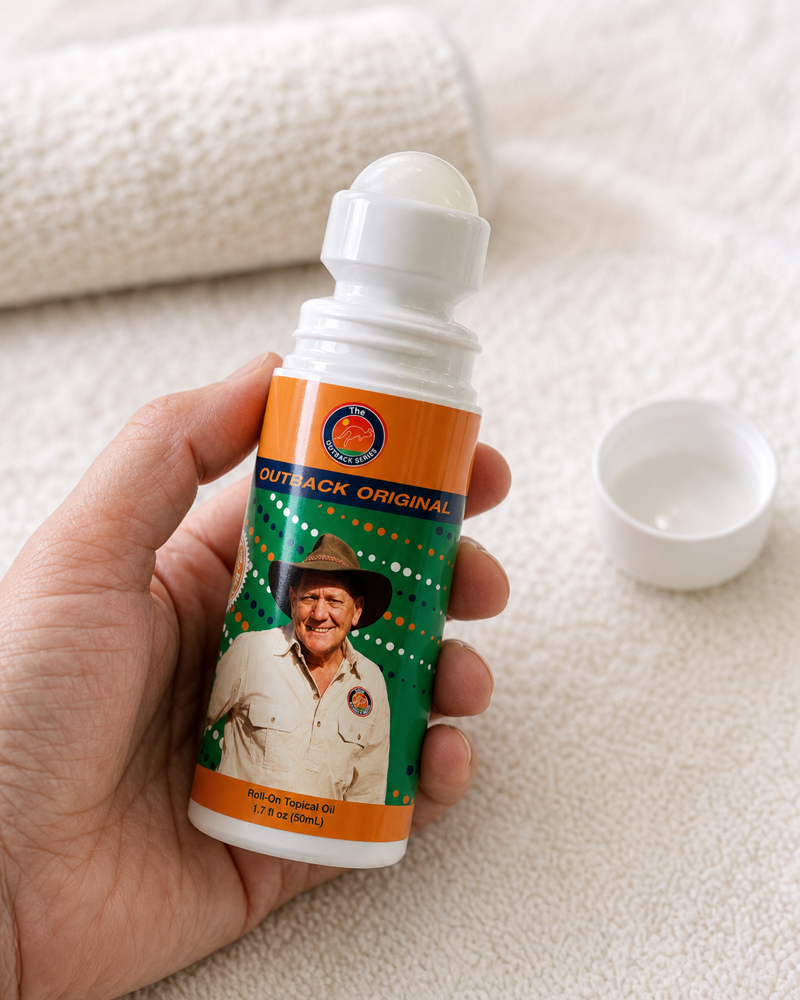 Hand holding the Outback Original Oil 50mL roll-on bottle